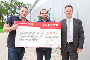 Hetzner Online Head of Marketing Christian Fitz presents the symbolic donation check to the club's managing director, Michael Grüb, and treasurer, Matthias Menhorn.